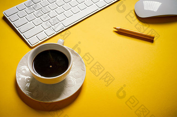 前视图白色键盘杯咖啡黄色的桌子上