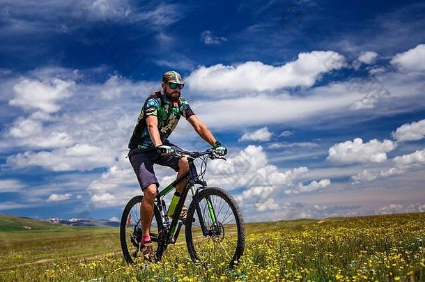 骑自行车的人游乐设施山开花字段自行车之旅户外高山歌曲作弊湖吉尔吉斯斯坦
