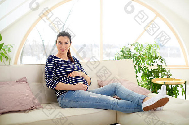 完整的长度拍摄美丽的怀孕了女人喜欢怀孕放松沙发首页