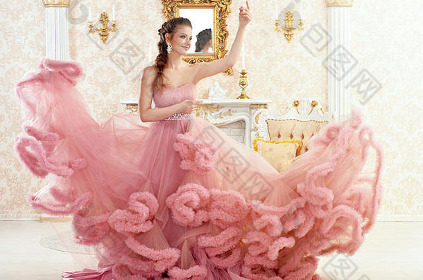 肖像美丽的年轻的女人粉红色的衣服