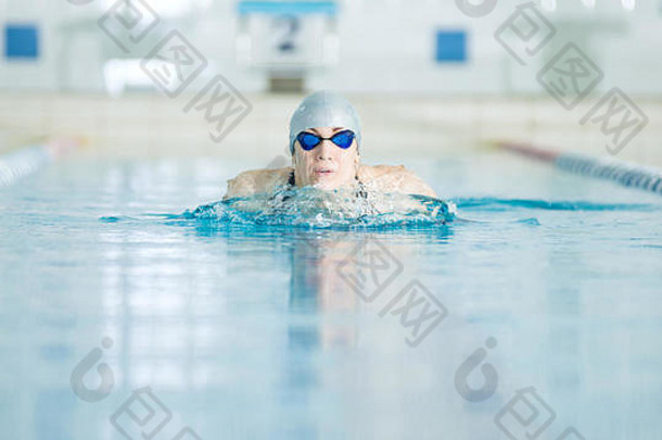 年轻的女孩护目镜游泳蛙泳中风风格
