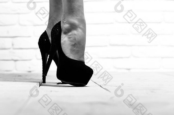 女有条理的腿黑色的时尚鞋子高高跟鞋木地板上白色砖墙背景复制空间