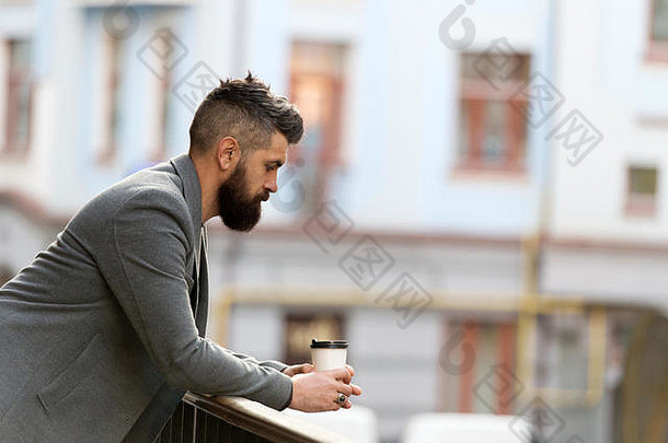 城市生活方式商人培养外观享受咖啡打破业务中心城市背景放松充电男人。有胡子的赶时髦的人喝咖啡纸杯sip咖啡
