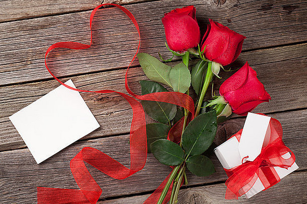 红色的玫瑰情人节一天问候卡礼物盒子木表格前视图复制空间