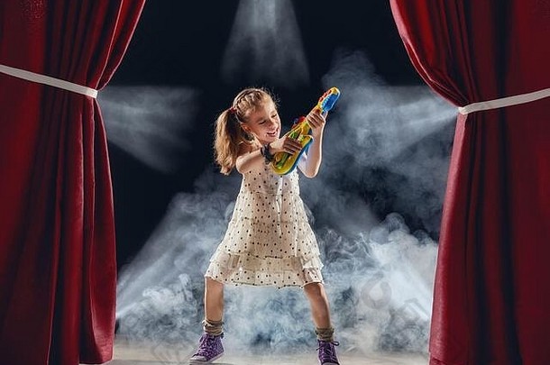 可爱的孩子女孩玩吉他阶段孩子梦想岩石音乐家