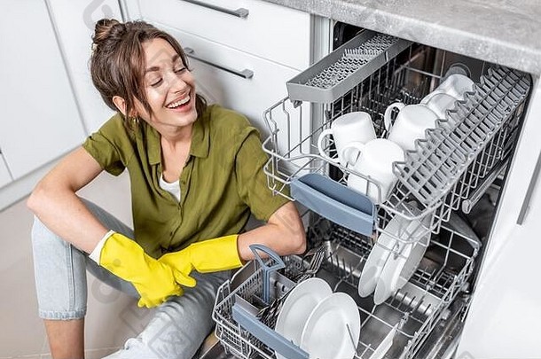肖像快乐家庭主妇坐着洗碗机<strong>清洁</strong>菜厨房首页容易房子工作厨房电器概念