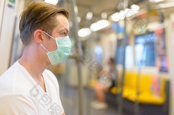 年轻的男人。穿面具保护电晕病毒爆发内部火车