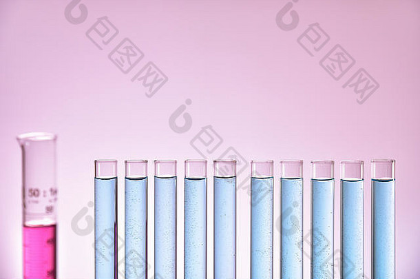 行完整的玻璃测试管蓝色的液体测量油缸粉红色的梯度背景前面视图