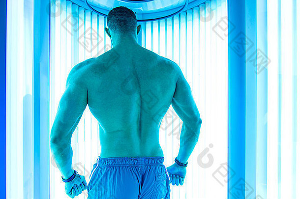 年轻的肌肉发达的男人。日光浴室美沙龙