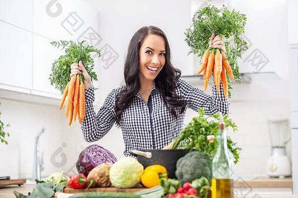 好玩的年轻的女人厨房持有新鲜的胡萝卜手饮食蔬菜希斯概念