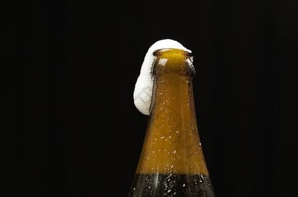 打开冷瓶啤酒冷啤酒黑色的背景工艺啤酒瓶冷凝物水滴特写镜头拍摄