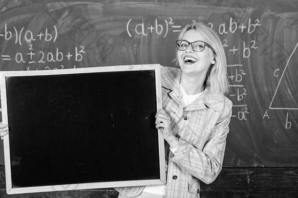 老师显示学校广告的地方学校新闻学校时间表额外的类老师女人持有黑板上空白广告复制空间学校信息传入的学生