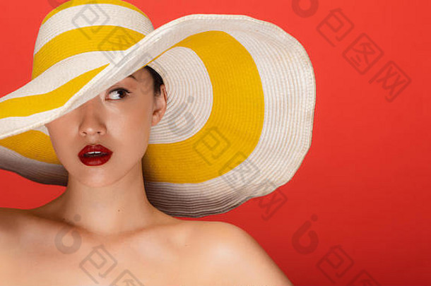 关闭肖像有吸引力的年轻的亚洲女人穿夏天他盯着一边红色的背景
