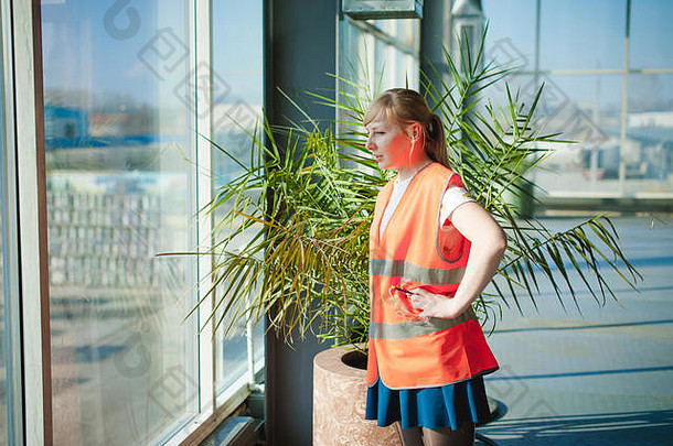 女员工橙色袍穿背心工作空间<strong>生产</strong>房间背景大窗户天花板地板上控制