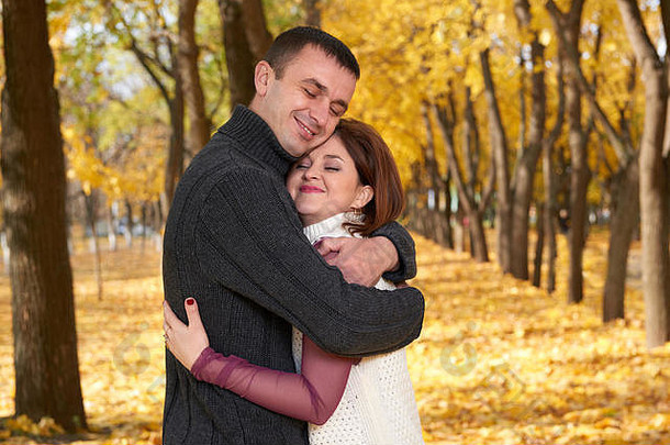 浪漫的人快乐成人夫妇拥抱秋天城市公园树黄色的叶子明亮的太阳快乐情绪温柔的