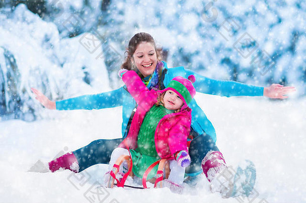 年轻的妈妈。女孩享受雪橇骑孩子滑雪橇蹒跚学步的孩子骑雪橇孩子们玩在户外雪