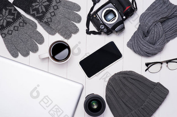 男人的冬天休闲服装相机咖啡杯移动PC智能手机眼镜木背景