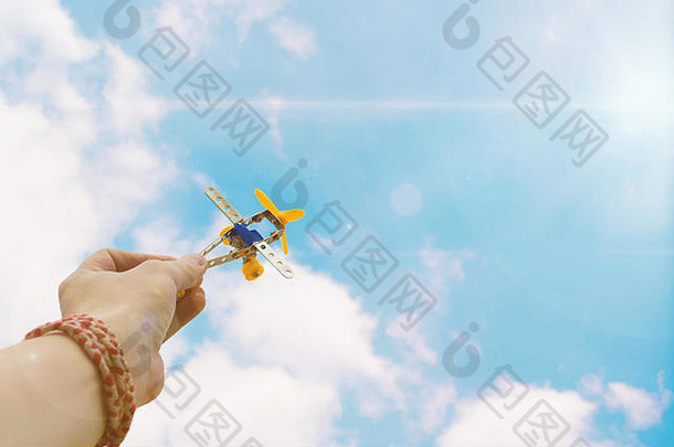 关闭照片男人的手持有玩具飞机蓝色的天空