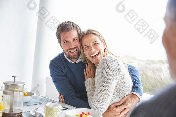 快乐充满深情的夫妇笑拥抱天井早餐