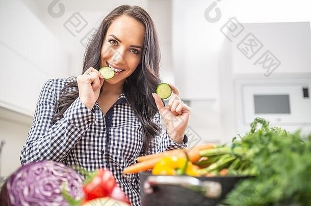 快乐的年轻的女人持有片黄瓜厨房饮食蔬菜希斯概念
