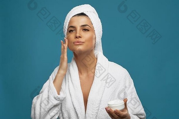 前面视图年轻的女人浴袍毛巾头奶油保湿振兴脸皮肤肖像漂亮的女淋浴孤立的蓝色的概念美护肤品