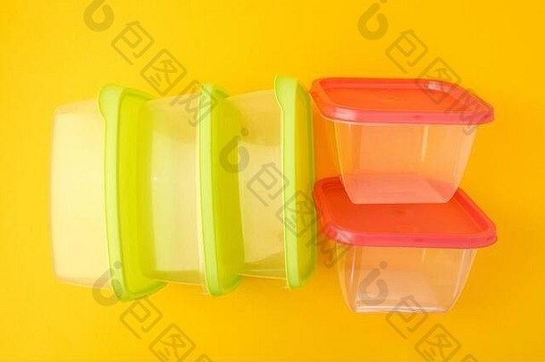 塑料午餐盒子黄色的背景色彩斑斓的塑料容器