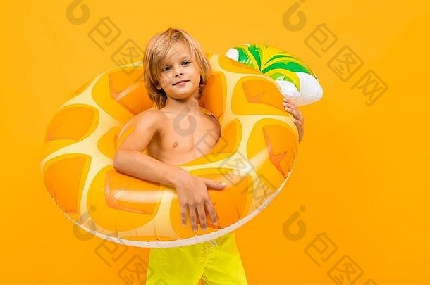 欧洲金发碧眼的男孩黄色的游泳树干游泳圆菠萝橙色背景