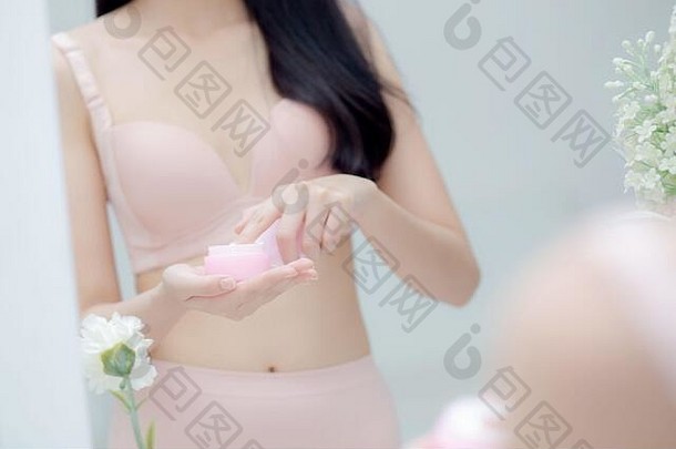 特写镜头手年轻的亚洲女人持有产品化妆品应用奶油Jar美丽的女孩手触摸乳液复兴美完美的