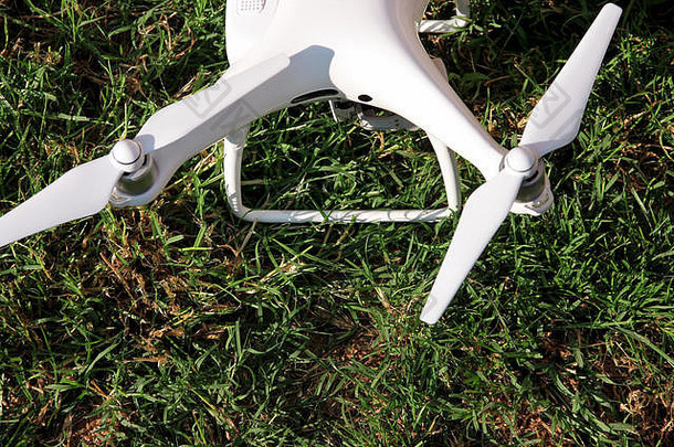 白色四轴飞行器无人机数字相机草准备好了飞空气照片记录镜头无人机