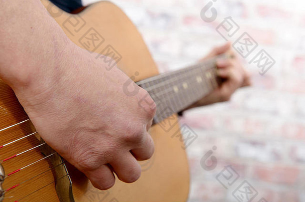 特写镜头视图男人的手玩声吉他