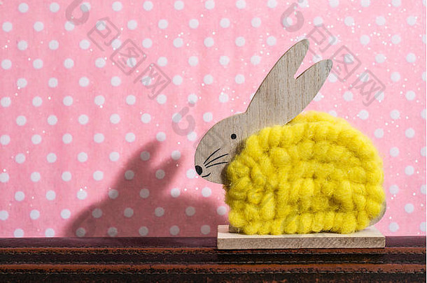 黄色的复活节兔子前面墙点房间兔子装饰粉红色的壁纸背景点影子兔子墙木