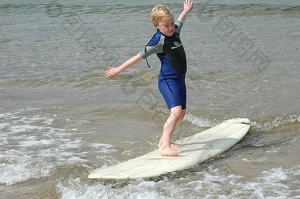 年轻的男孩学习冲浪贝尔黑文海滩东洛锡安苏格兰