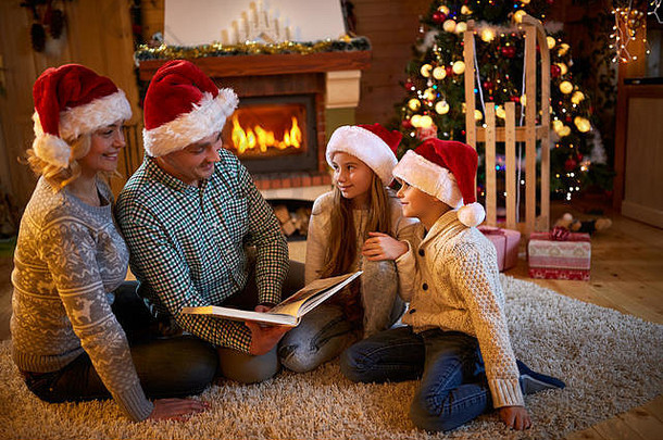 父母孩子们的读书壁炉圣诞节夏娃家庭孩子庆祝圣诞节