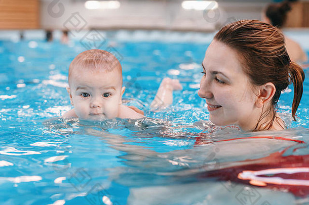 白色高加索人妈妈。转换新生儿婴儿浮动游泳池婴儿潜水水健康的活跃的生活方式家庭活动早期