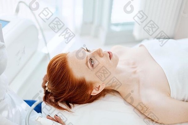 有吸引力的红色的头发的女人说谎沙发上医疗中心等待美按摩面部治疗美容美皮肤护理<strong>产值</strong>