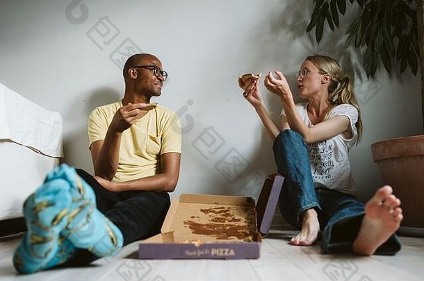 夫妇坐着地板上披萨
