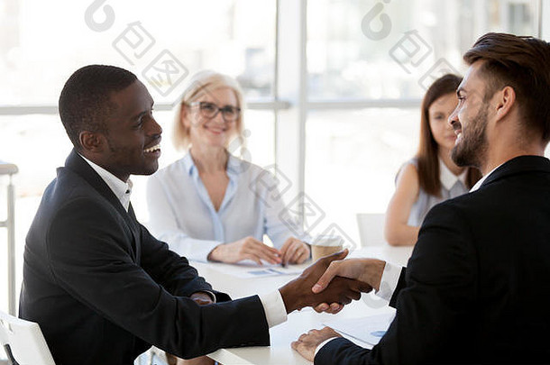 多样化的员工握手问候办公室会议