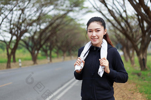 年轻的运动女人白色毛巾休息锻炼体育运动练习在户外公园
