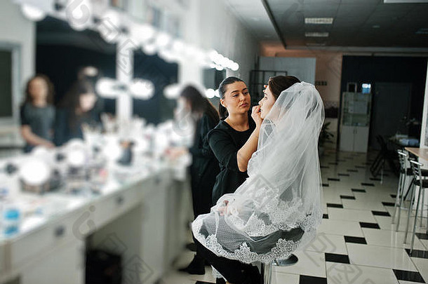 使艺术家专业化妆年轻的女人新娘镜子美工作室早....婚礼一天