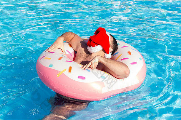 男人。圣诞节他走游泳池阳光明媚的一天感觉放松