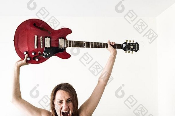 女人持有电吉他尖叫