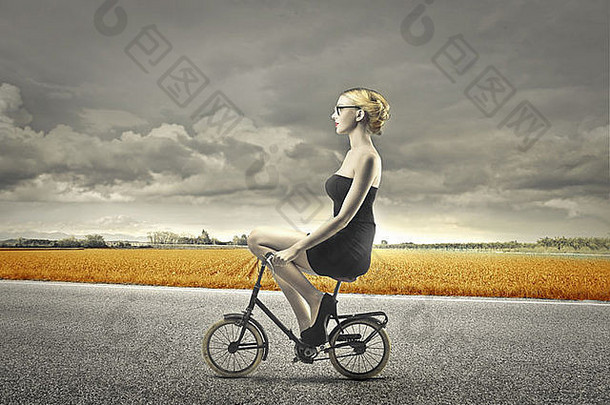 金发女郎女孩黑色的衣服自行车
