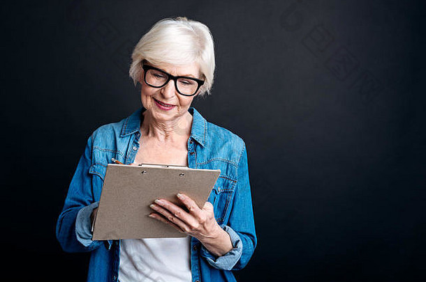 愉快的岁的女人使笔记