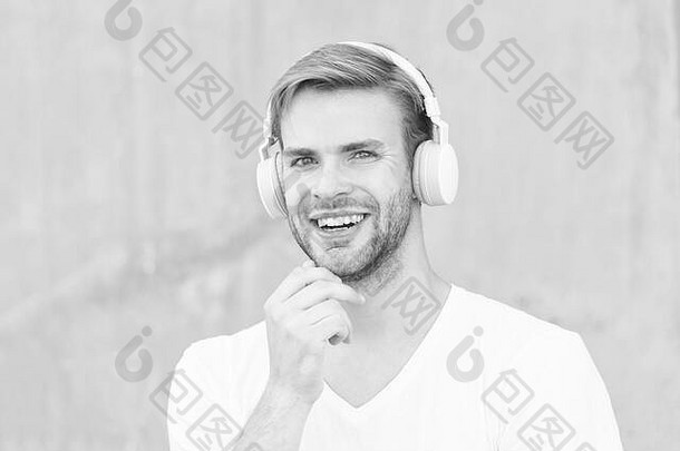 耳机合适的头大小快乐的家伙穿耳机灰色背景英俊的男人。<strong>微</strong>笑耳朵<strong>立体</strong>声耳机现代设计耳机技术生活生活大声