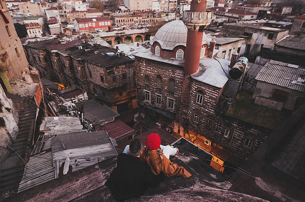 夫妇爱坐着屋顶视图晚上伊斯坦布尔休闲风格秋天红色的贝雷帽米色外套