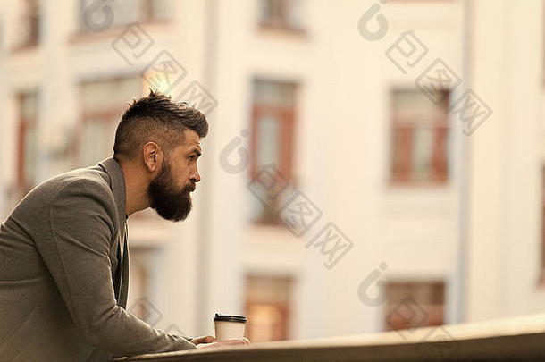 商人培养外观享受咖啡打破业务中心城市背景放松充电男人。有胡子的赶时髦的人喝咖啡纸杯sip咖啡城市生活方式