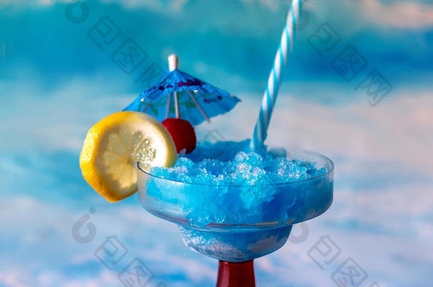 色彩斑斓的蓝色的鸡尾酒柠檬樱桃装饰蓝色的喝伞