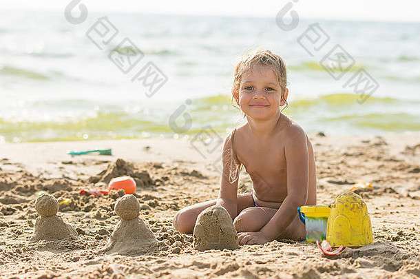 孩子坐在海滨造型沙子蛋糕