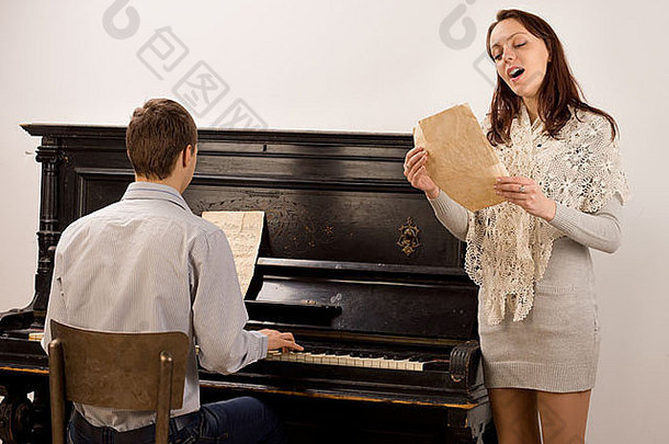 年轻的女人唱歌只有首歌站与年轻的男人。玩正直的计划唱歌明显的享受