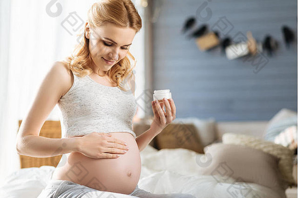 怀孕了女人轻轻摩擦奶油肚子